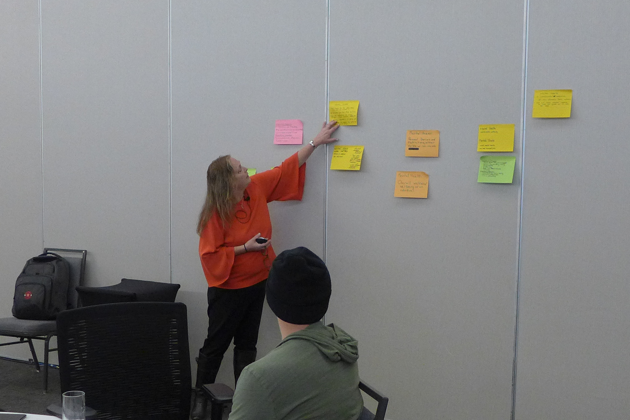 Presenter putting coloured notes on the wall