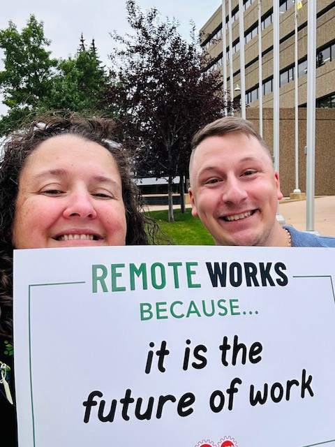participants holding a sign remote works because it is the future of work