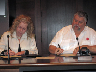Linda Lizotte-MacPherson and Robert Campbell signing the document