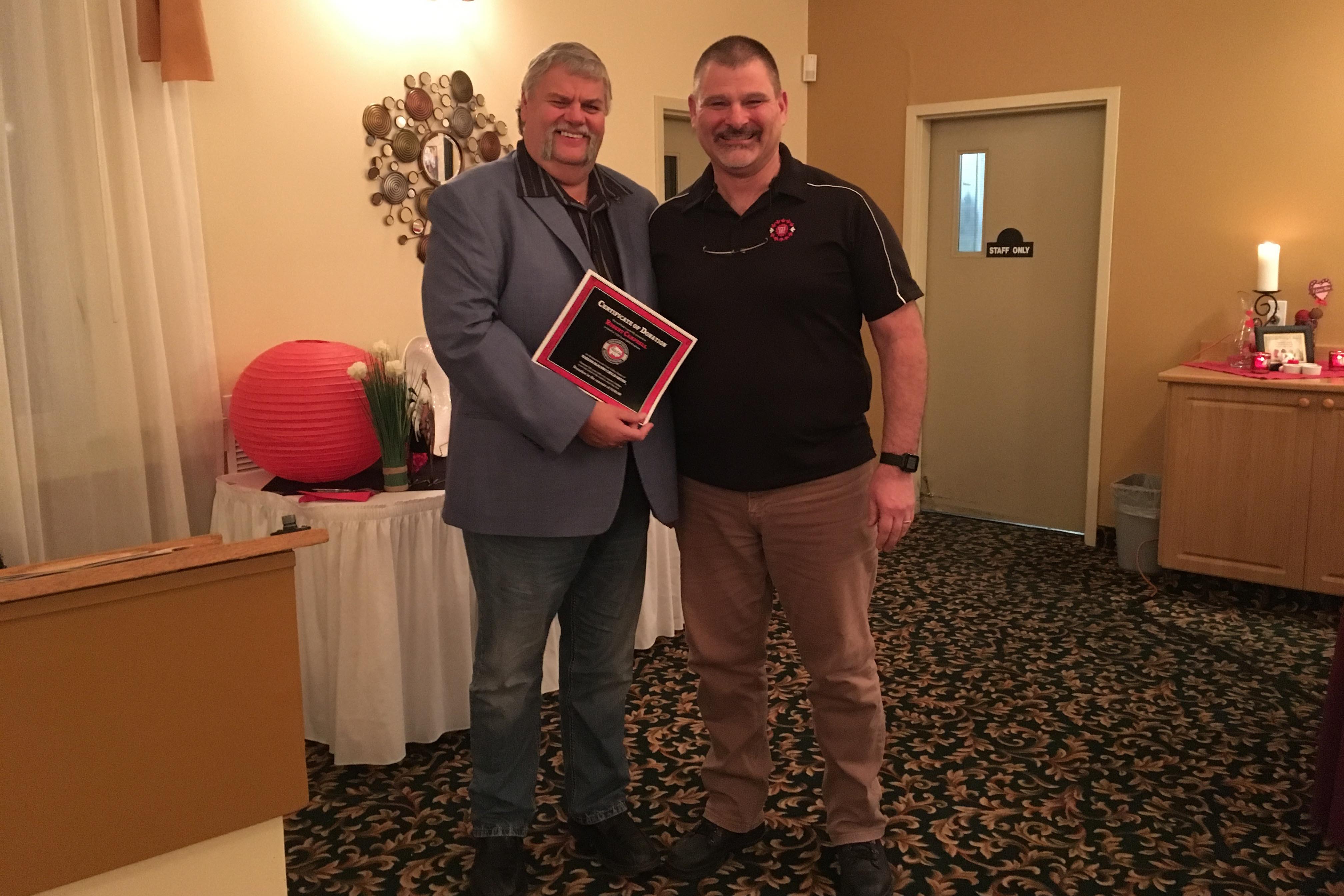 Bob Campbell receiving the donation certificate from Local President Derek Johannson