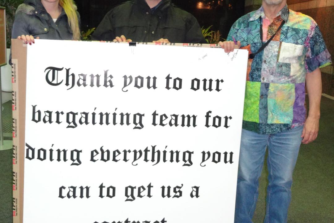 Daria Askerko, Iain MacFarlane et Jim Weir posant avec la carte dans l'entrée du Centre d'appels