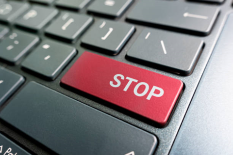 keyboard with a red key with the word STOP in white